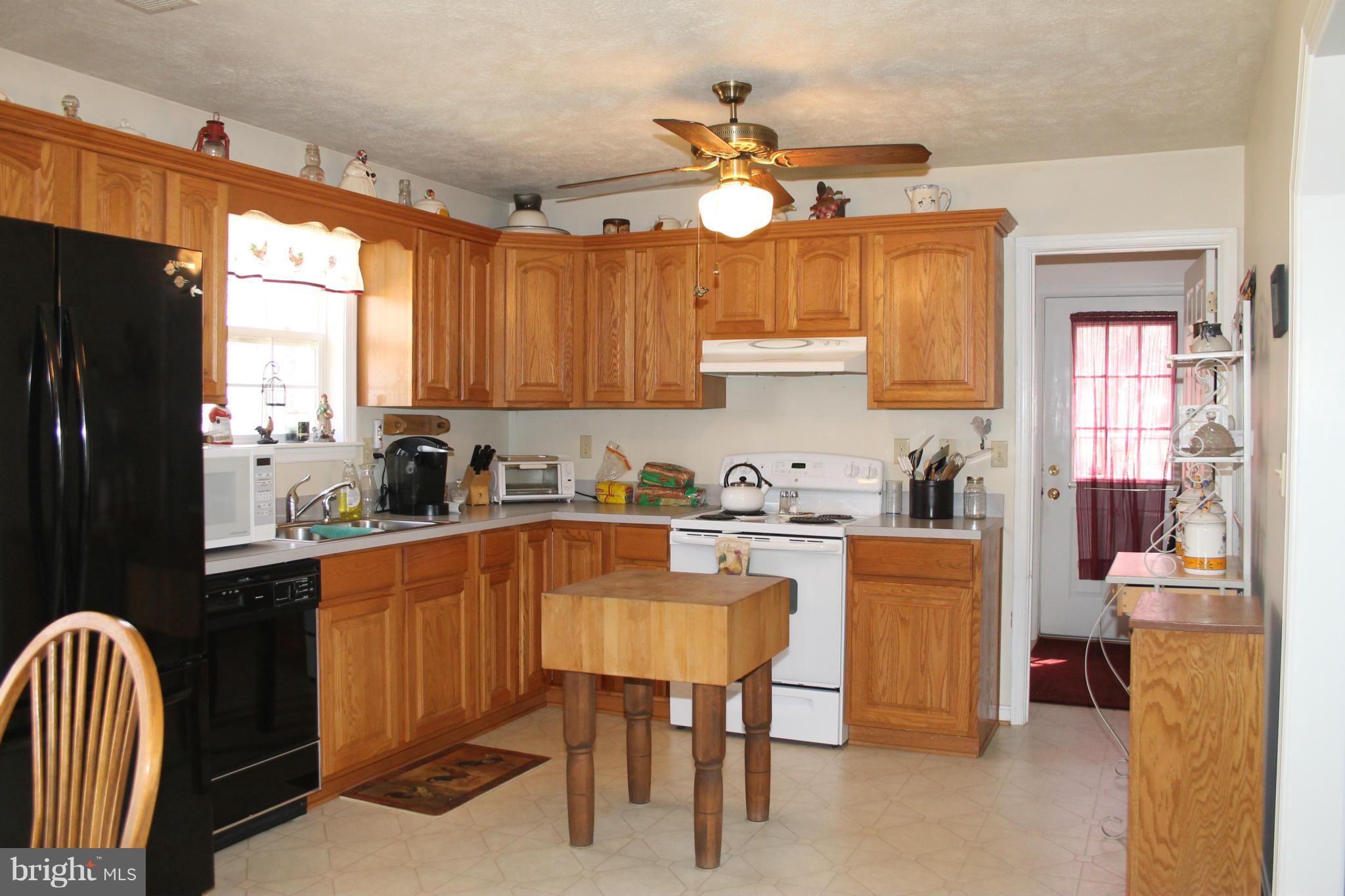 10275 Dutch Hollow Road Rixeyville, VA 22737 - Photo 7 of 21 a kitchen with granite countertop a sink dining table and chairs
