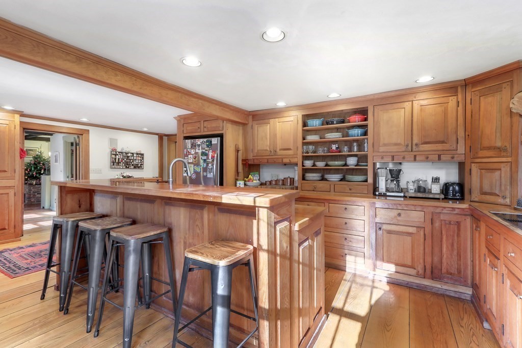 150 Concord Road Sudbury, MA 01776 - Photo 7 of 34 a kitchen with stainless steel appliances kitchen island granite countertop a table and chairs in it