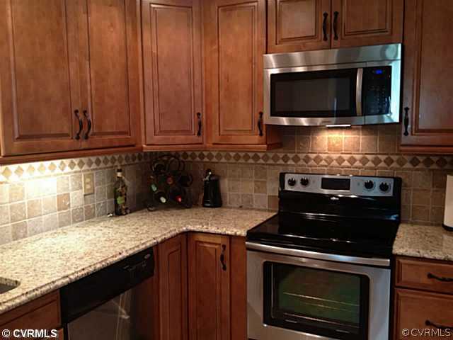 15504 Nash Road Dewitt, VA 23840 - Photo 2 of 18 a kitchen with granite countertop a stove top oven microwave and cabinets
