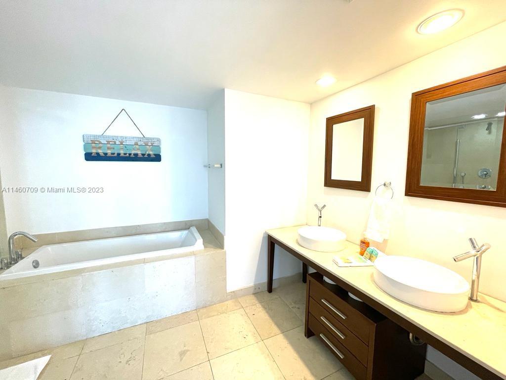 Brickell Miami, FL 33131 - Photo 25 of 27 a bathroom with a tub sink and mirror