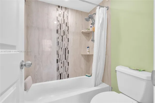 a bathroom with a granite countertop sink a mirror and a bathtub