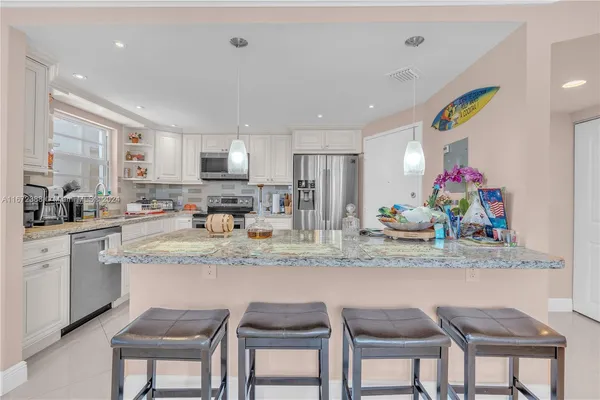 a kitchen with stainless steel appliances granite countertop a sink and dishwasher with white cabinets