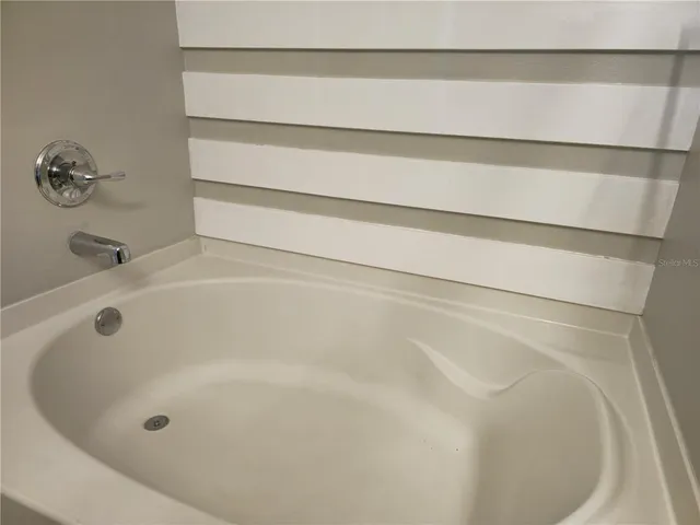 a bathroom with a granite countertop sink and a bathtub