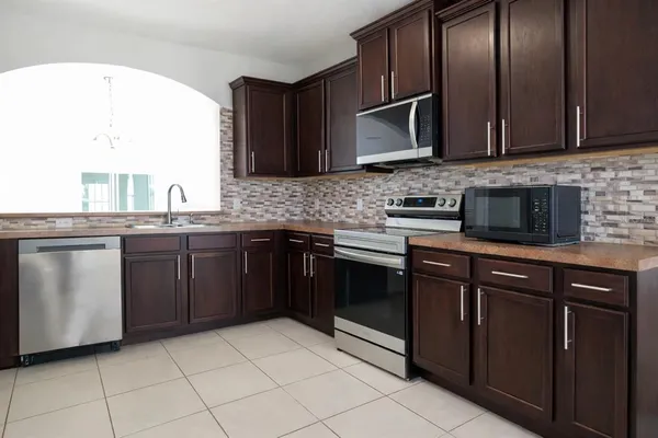 a kitchen with stainless steel appliances granite countertop a sink and a stove