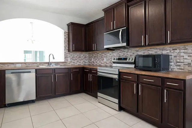 a kitchen with stainless steel appliances granite countertop a sink and a stove