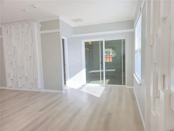 a view of a room with wooden floor and sliding glass door