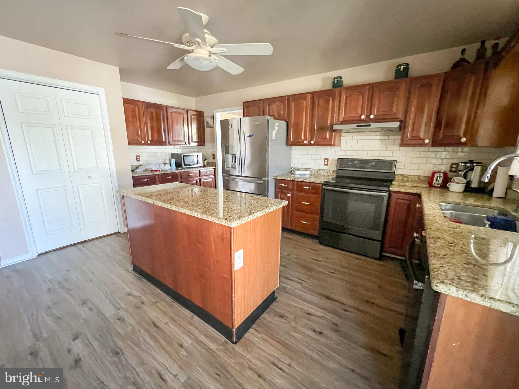 214 Mt Vernon Drive Bear, DE 19701 - Photo 11 of 44 a kitchen with stainless steel appliances granite countertop a stove top oven a refrigerator a sink and dishwasher with wooden floor
