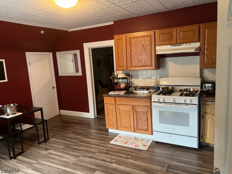 21 Chadwick Street Paterson, NJ 07503 - Photo 11 of 14 a kitchen with granite countertop a stove cabinets and wooden floor