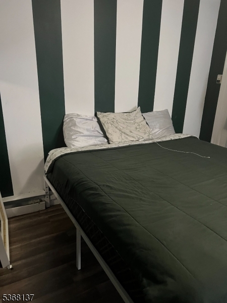 21 Chadwick Street Paterson, NJ 07503 - Photo 5 of 14 a bedroom with a bed and wooden floor