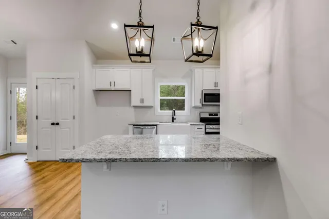 a kitchen with stainless steel appliances granite countertop a sink and a stove