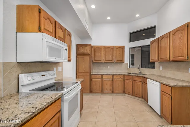 a kitchen with stainless steel appliances granite countertop a sink and dishwasher a stove top oven with wooden floor