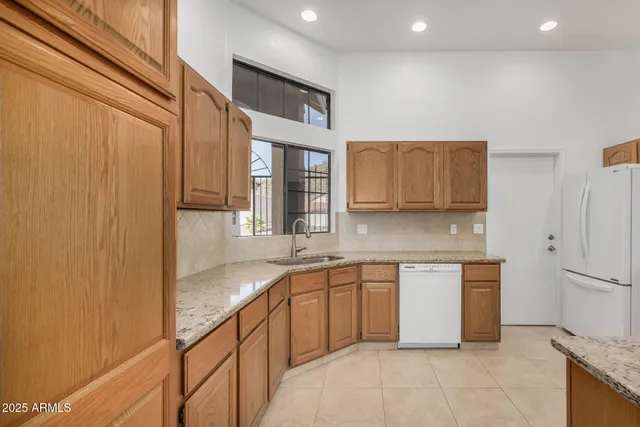 a kitchen with stainless steel appliances granite countertop a sink and cabinets with wooden floor