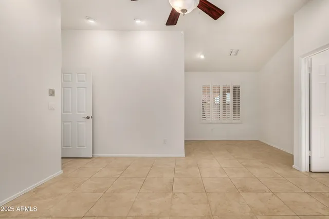an empty room with fan and windows