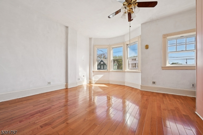 55 Thompson Street Raritan, NJ 08869 - Photo 14 of 23 an empty room with wooden floor chandelier and windows