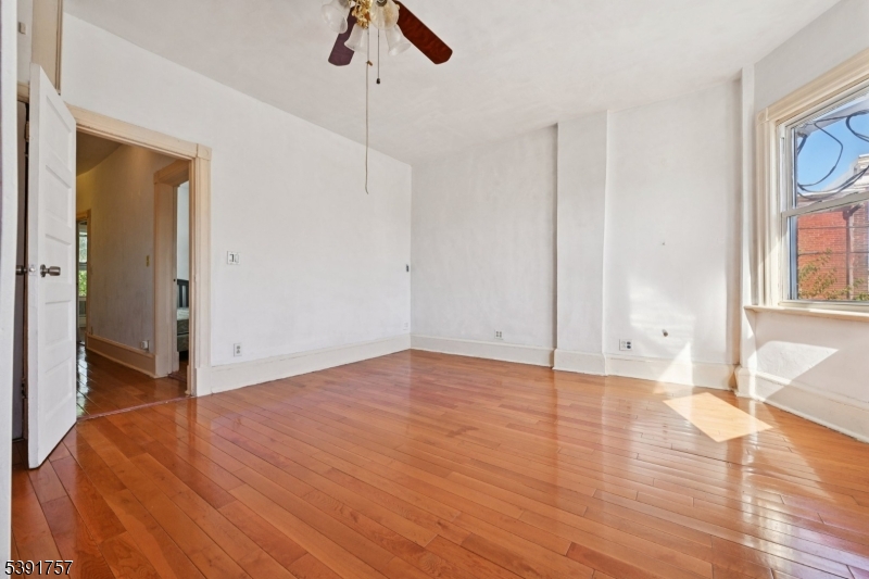 55 Thompson Street Raritan, NJ 08869 - Photo 17 of 23 a view of an empty room with window and wooden floor