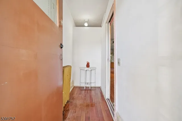 a view of a hallway with wooden floor