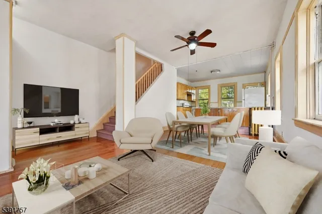 a living room with furniture flat screen tv and a large window