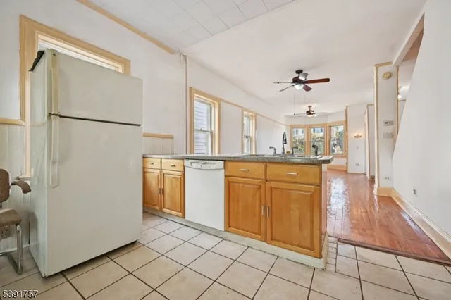 a kitchen with white cabinets and refrigerator