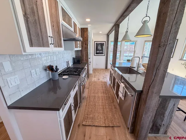 a kitchen with stainless steel appliances granite countertop a sink a stove and a refrigerator