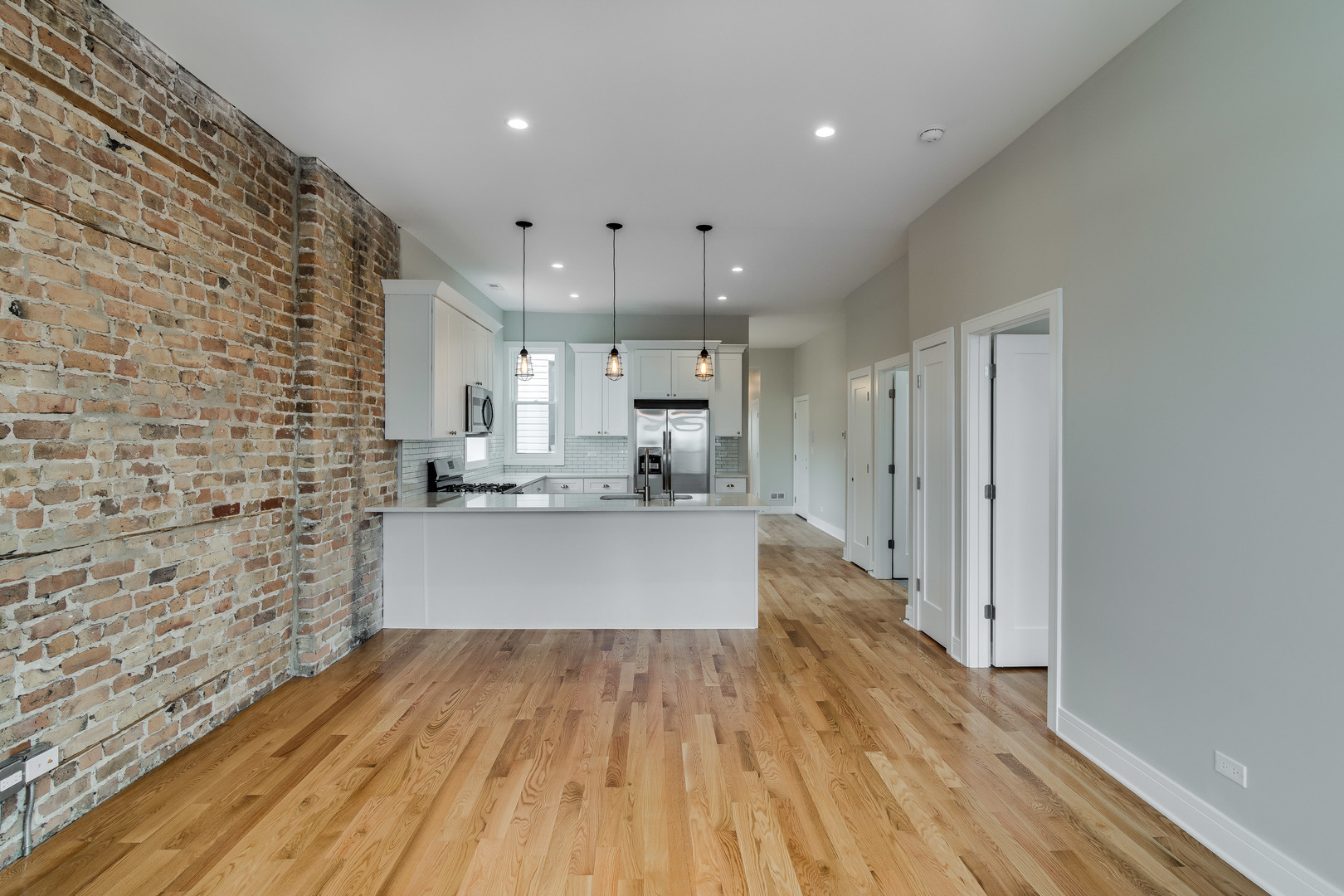 965 West 18th Street Chicago, IL 60608 - Photo 21 of 46 a large kitchen with stainless steel appliances a large counter top a stove and a wooden floor