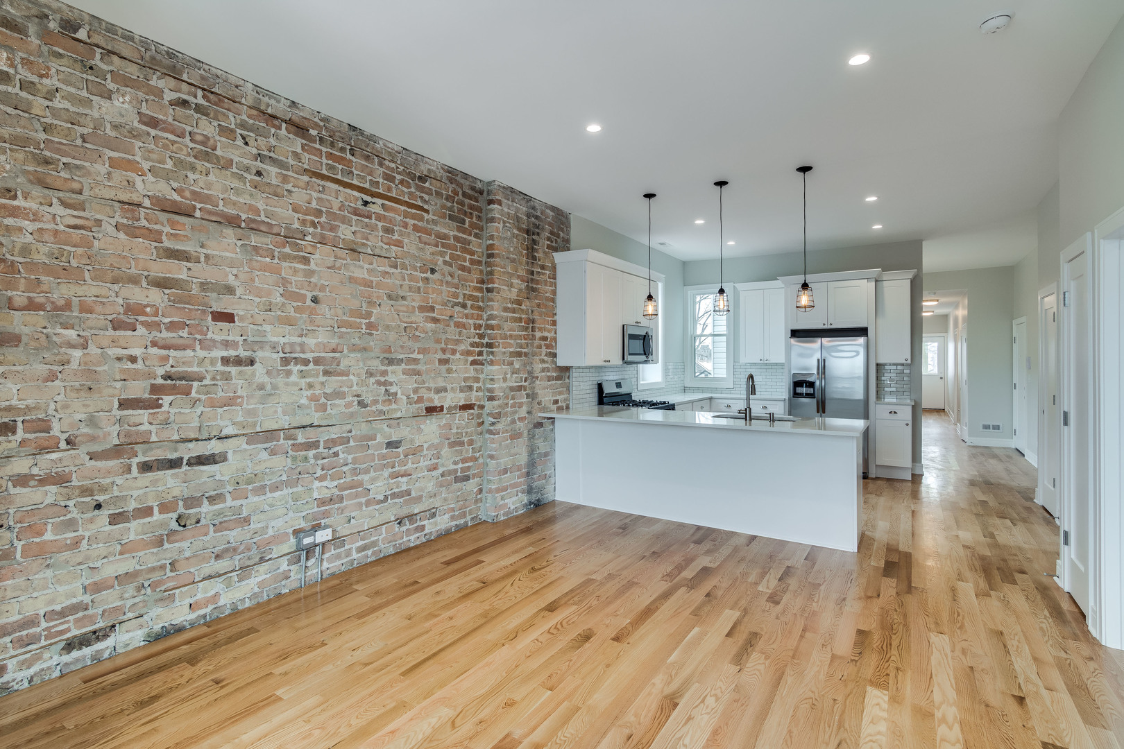 965 West 18th Street Chicago, IL 60608 - Photo 22 of 46 a large kitchen with stainless steel appliances kitchen island a large counter top a stove and a wooden floors