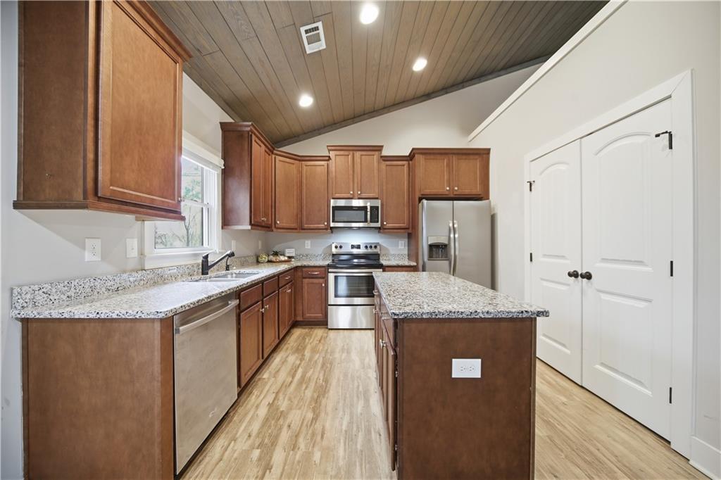 294 Town Creek Road Talking Rock, GA 30175 - Photo 13 of 68 a kitchen with stainless steel appliances granite countertop a stove a sink dishwasher and a refrigerator with wooden floor