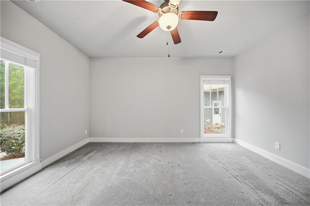 294 Town Creek Road Talking Rock, GA 30175 - Photo 21 of 68 an empty room with chandelier fan and windows