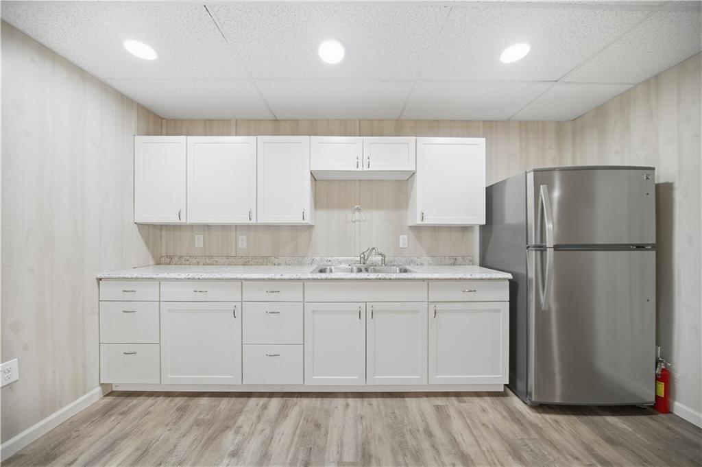294 Town Creek Road Talking Rock, GA 30175 - Photo 47 of 68 a kitchen with stainless steel appliances granite countertop a refrigerator a sink and white cabinets with wooden floor