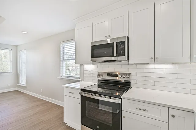 a kitchen with stainless steel appliances a stove microwave and sink