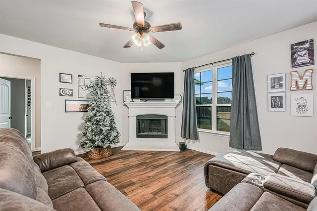 a living room with furniture a flat screen tv and a fireplace