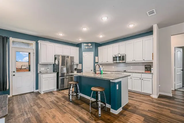 a kitchen with refrigerator cabinets and wooden floor