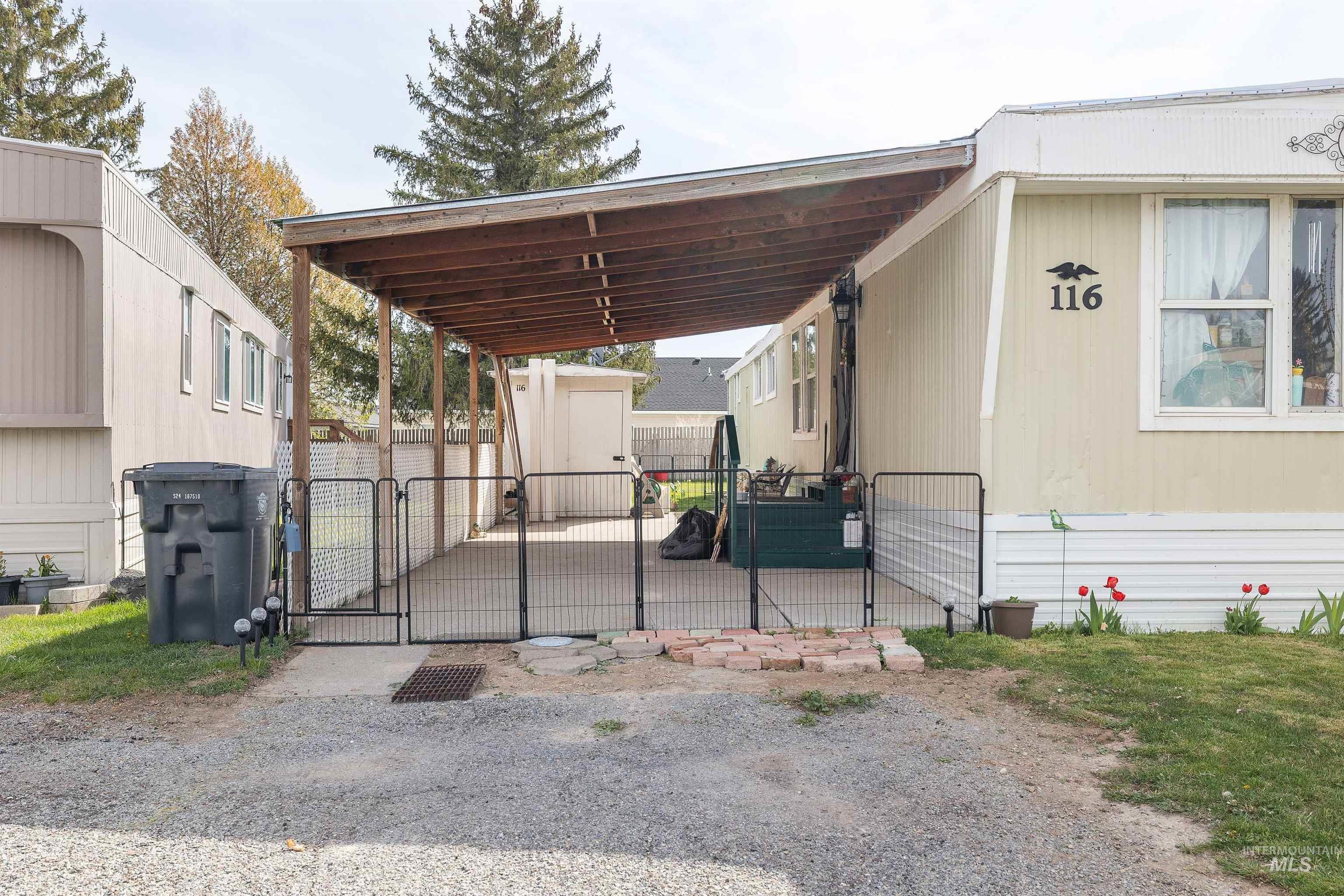 198 South Hills Road, Unit 116 Twin Falls, ID 83301 - Photo 17 of 21 View of parking with a storage unit, a gate, and an attached carport