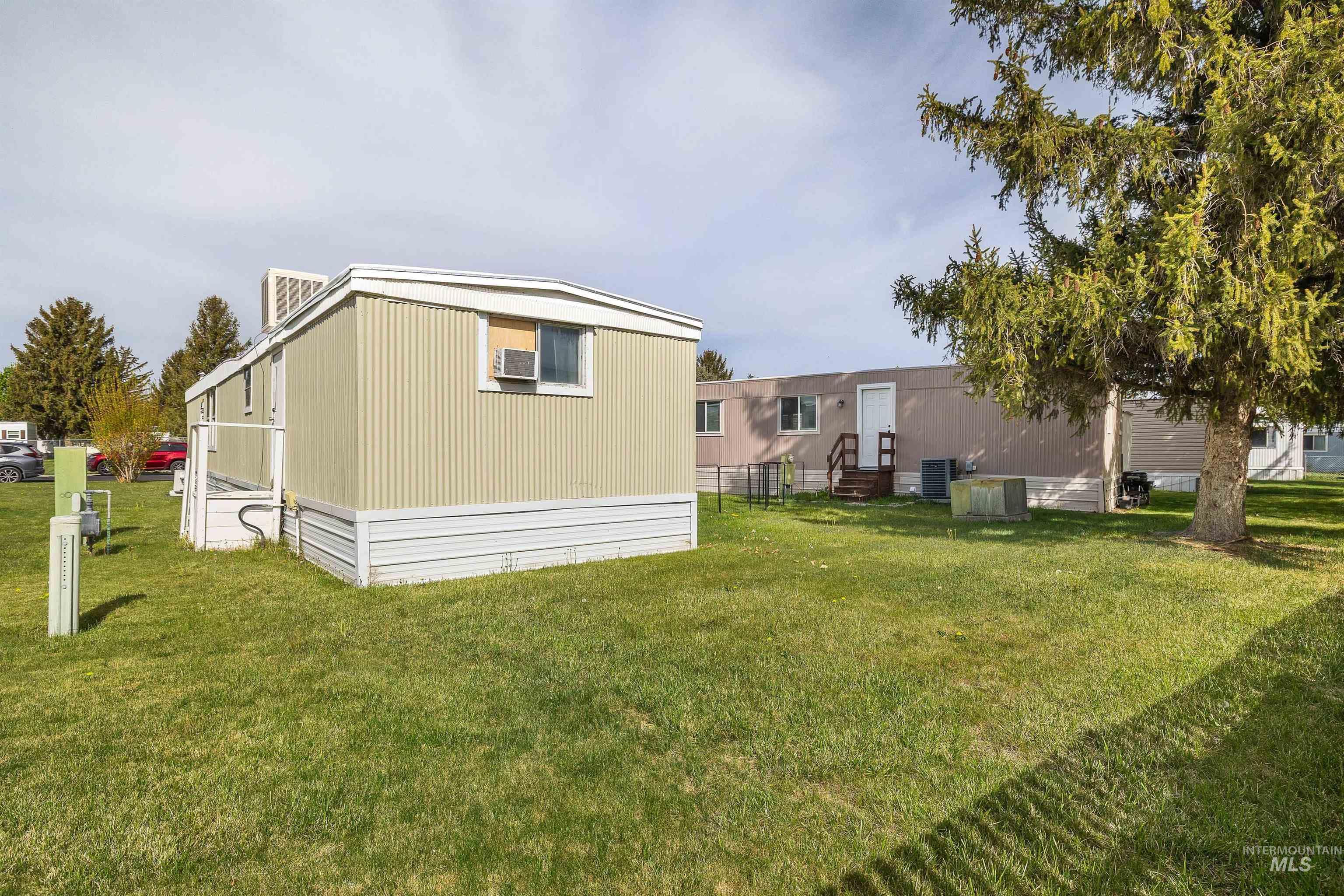 198 South Hills Road, Unit 116 Twin Falls, ID 83301 - Photo 20 of 21 Back of property with a lawn and entry steps