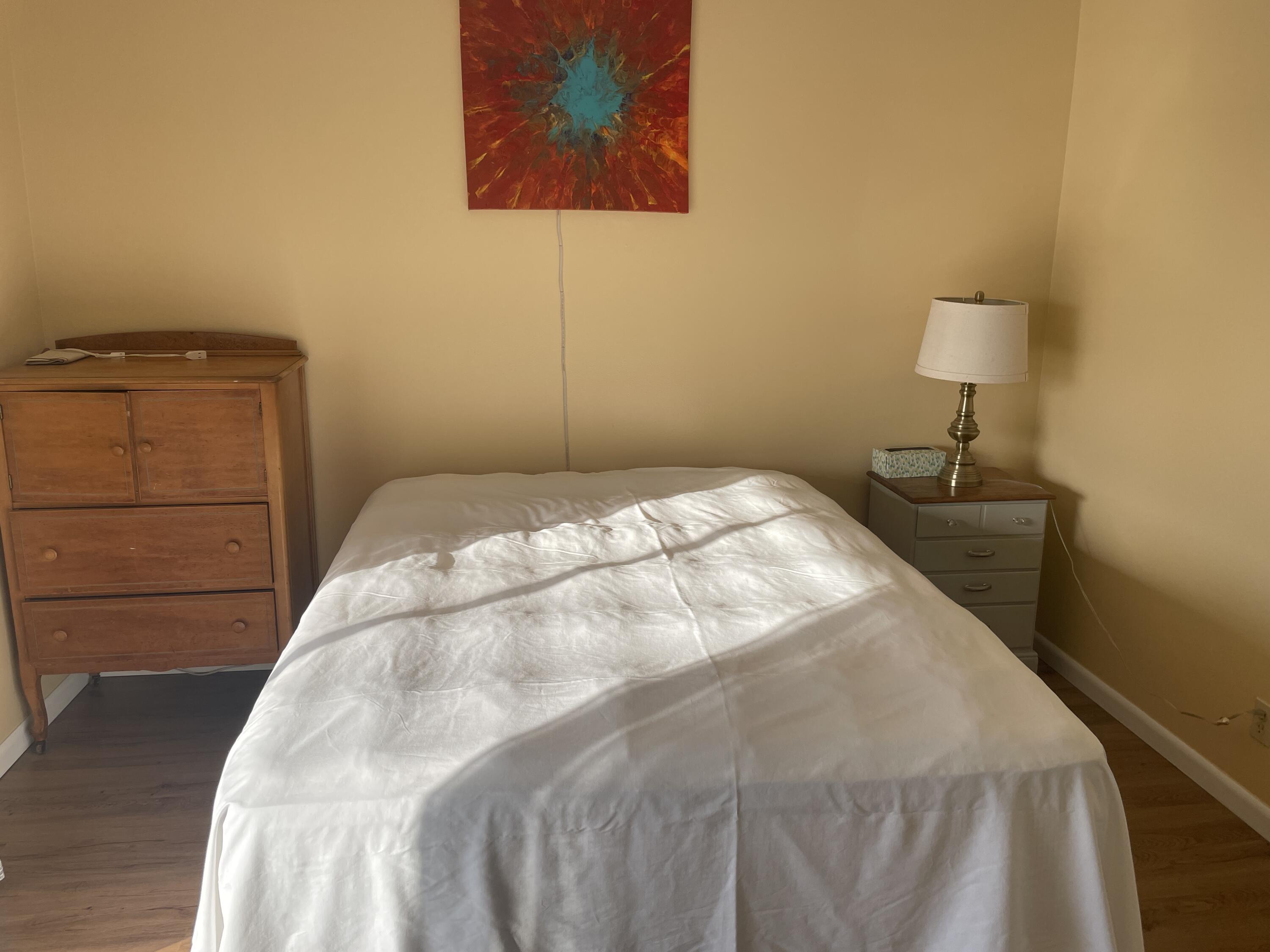 183 Dorchester East, Unit H West Palm Beach, FL 33417 - Photo 12 of 28 a bedroom with a bed and a night stand