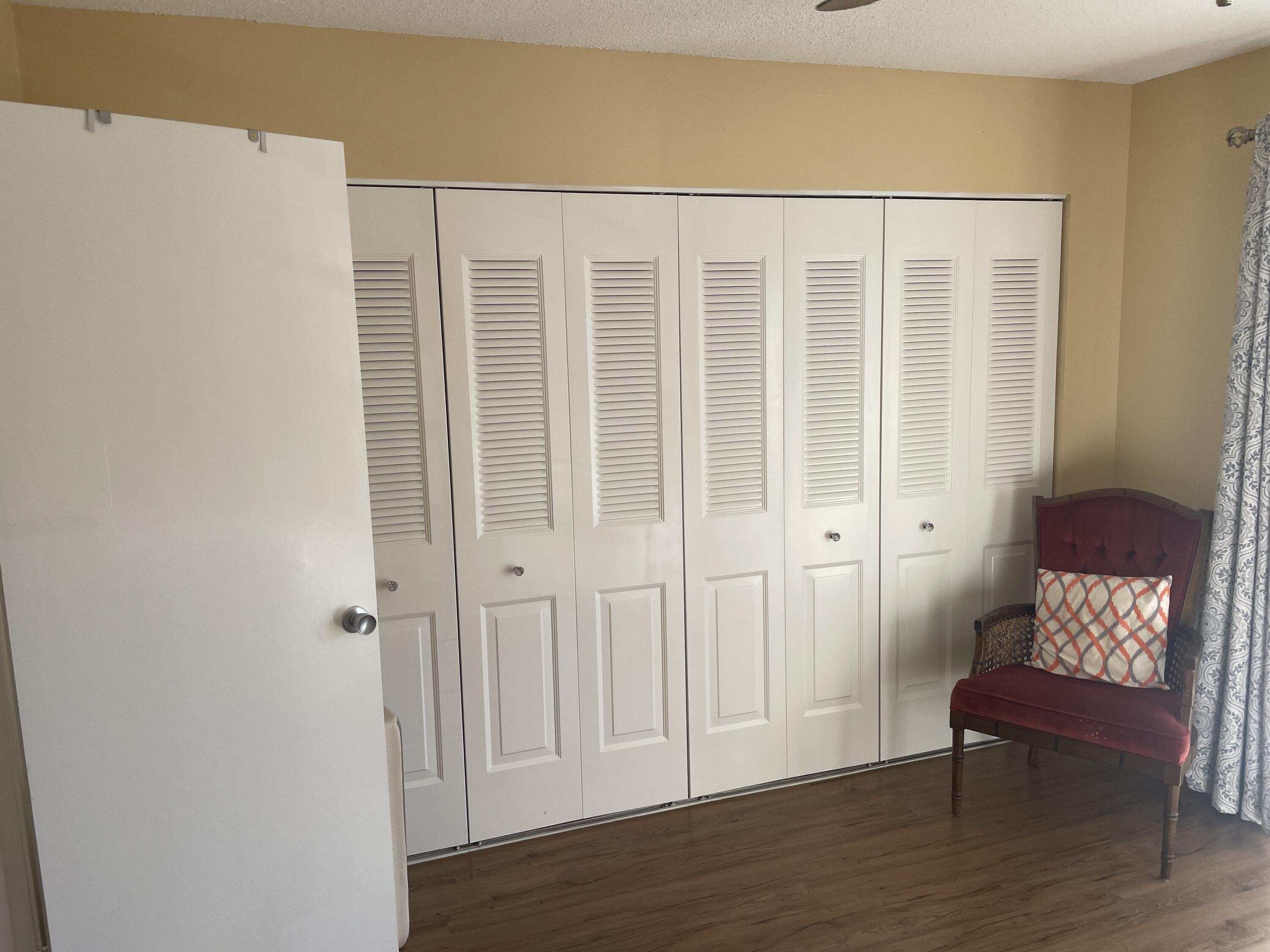 183 Dorchester East, Unit H West Palm Beach, FL 33417 - Photo 13 of 28 a view of a hallway with wooden floor and a cabinet