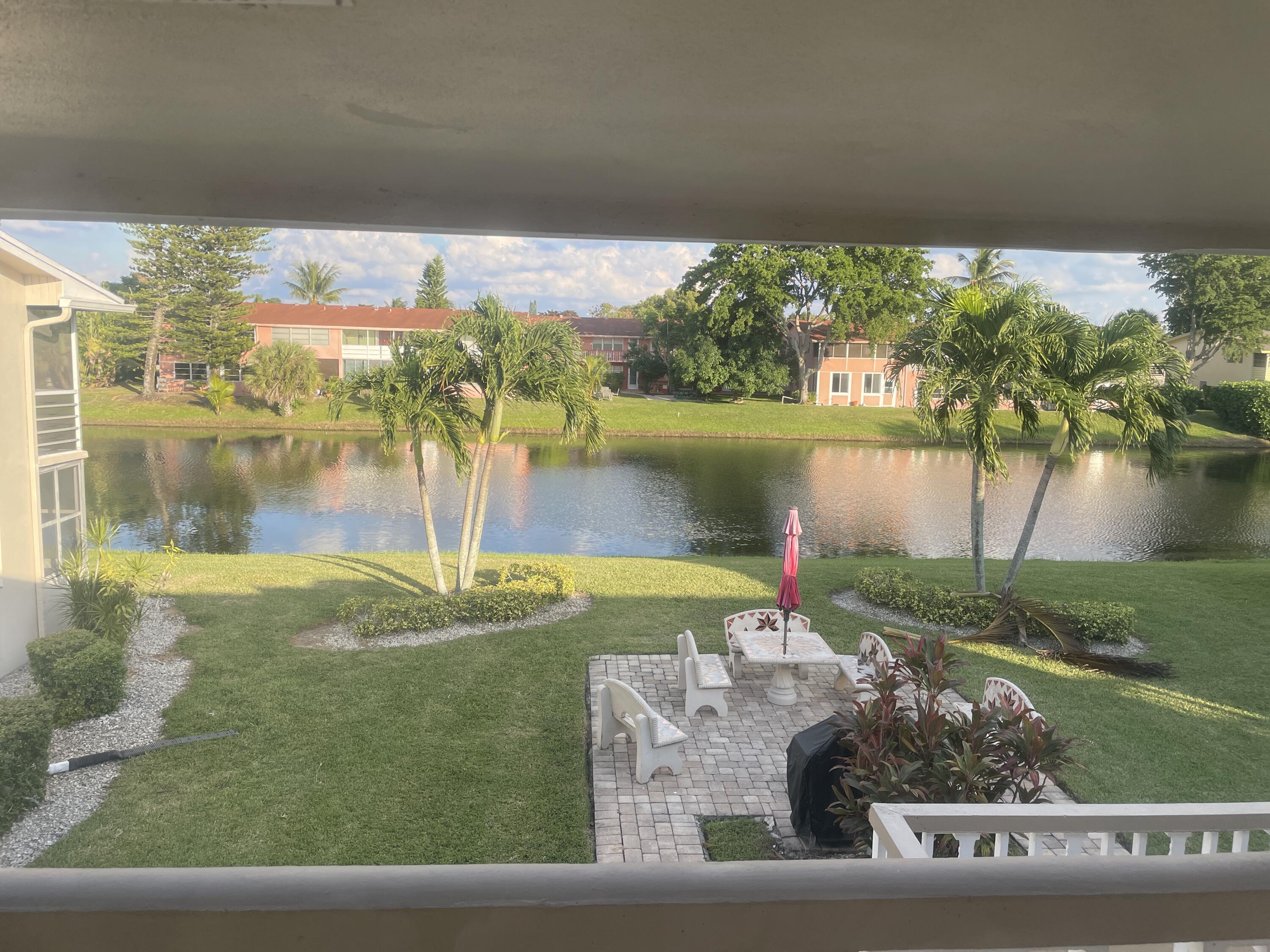 183 Dorchester East, Unit H West Palm Beach, FL 33417 - Photo 19 of 28 a view of a lake from a yard