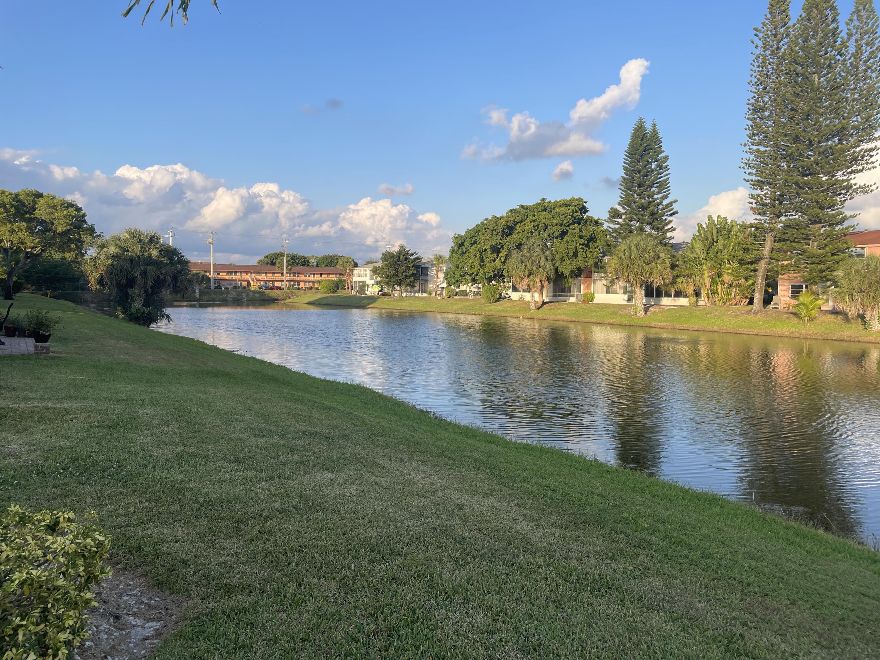 183 Dorchester East, Unit H West Palm Beach, FL 33417 - Photo 21 of 28 a view of a lake with houses in the background