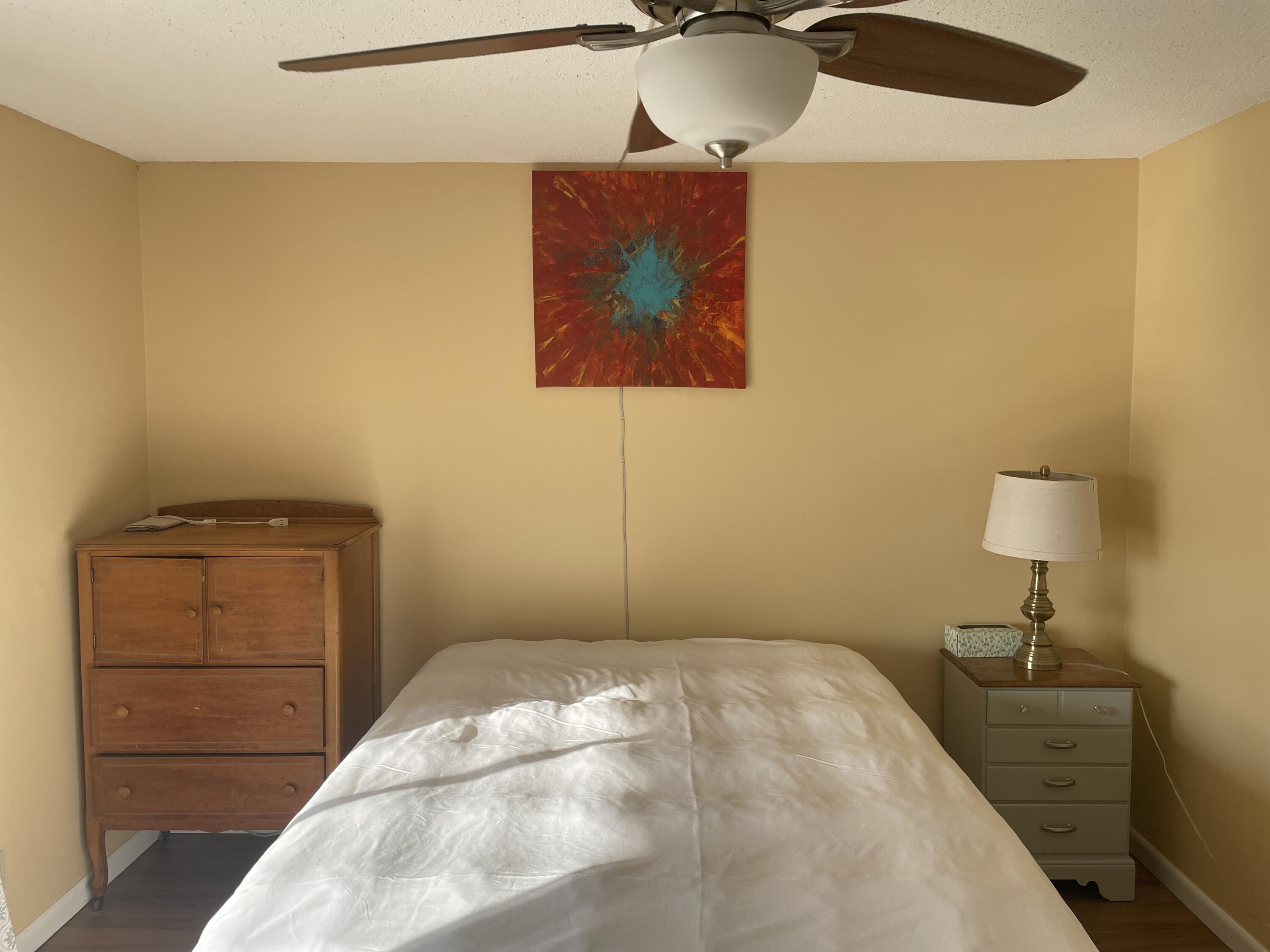 183 Dorchester East, Unit H West Palm Beach, FL 33417 - Photo 25 of 28 a bedroom with a bed and a painting on the wall