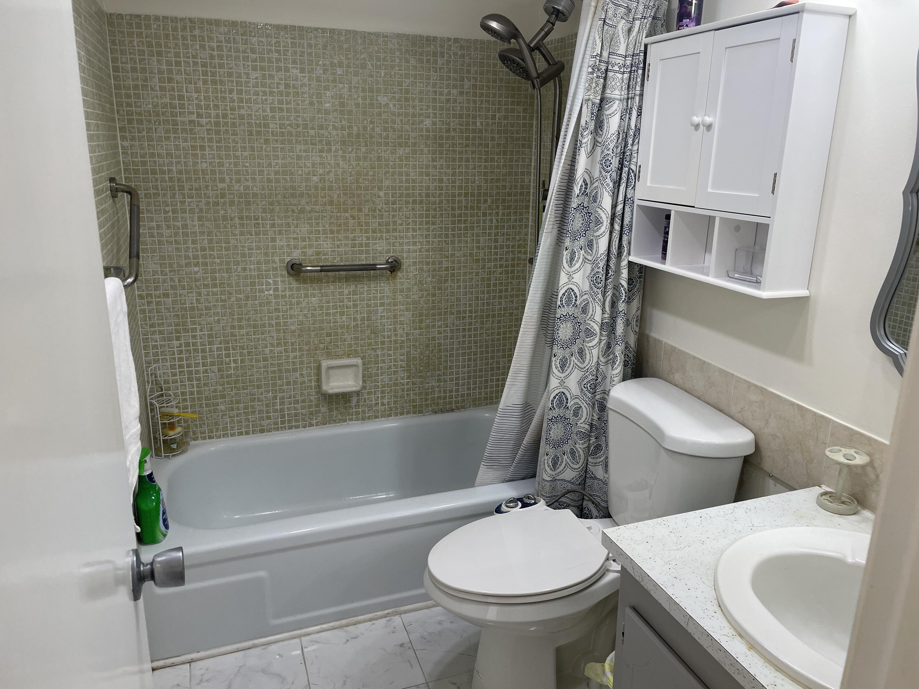 183 Dorchester East, Unit H West Palm Beach, FL 33417 - Photo 6 of 28 a bathroom with a sink toilet and shower
