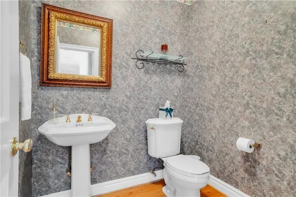 a bathroom with a toilet sink and mirror