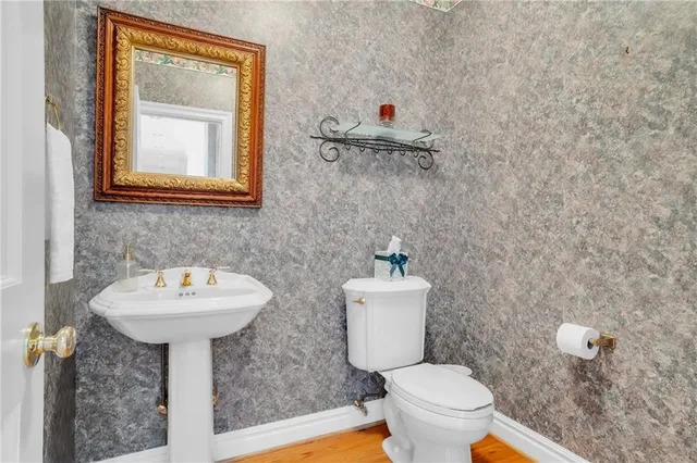 a bathroom with a toilet sink and mirror