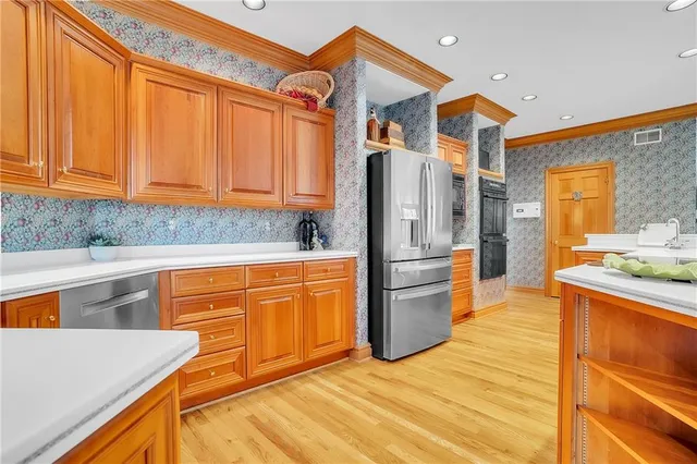 a kitchen with stainless steel appliances granite countertop a refrigerator and a sink