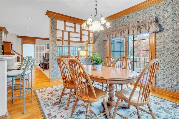 a dining room with furniture a chandelier and wooden floor