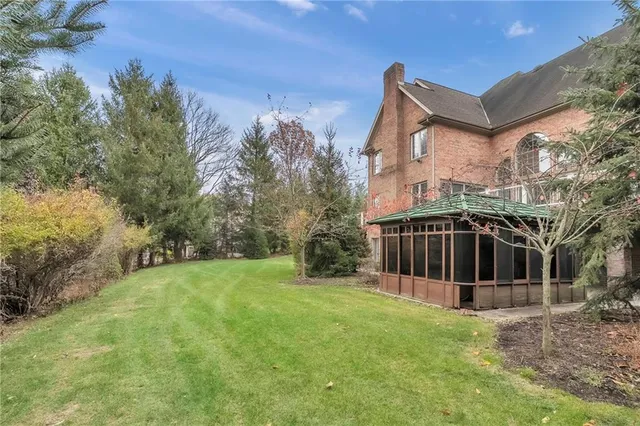 a view of a house with backyard and trees