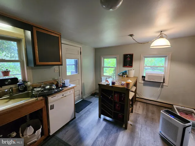 a kitchen with a stove a sink and wooden floor