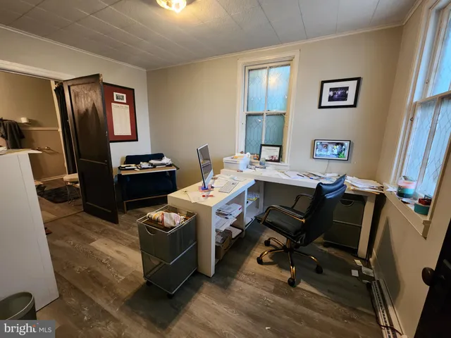 a view of a workspace with furniture and a window