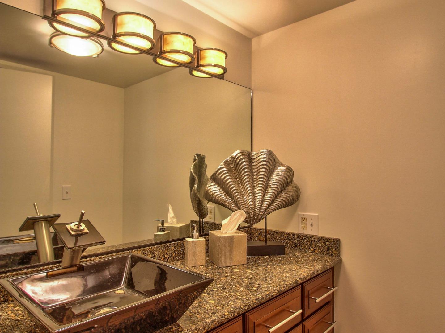 4130 Sunridge Road Pebble Beach, CA 93953 - Photo 4 of 31 a room with a granite countertop sink and a mirror