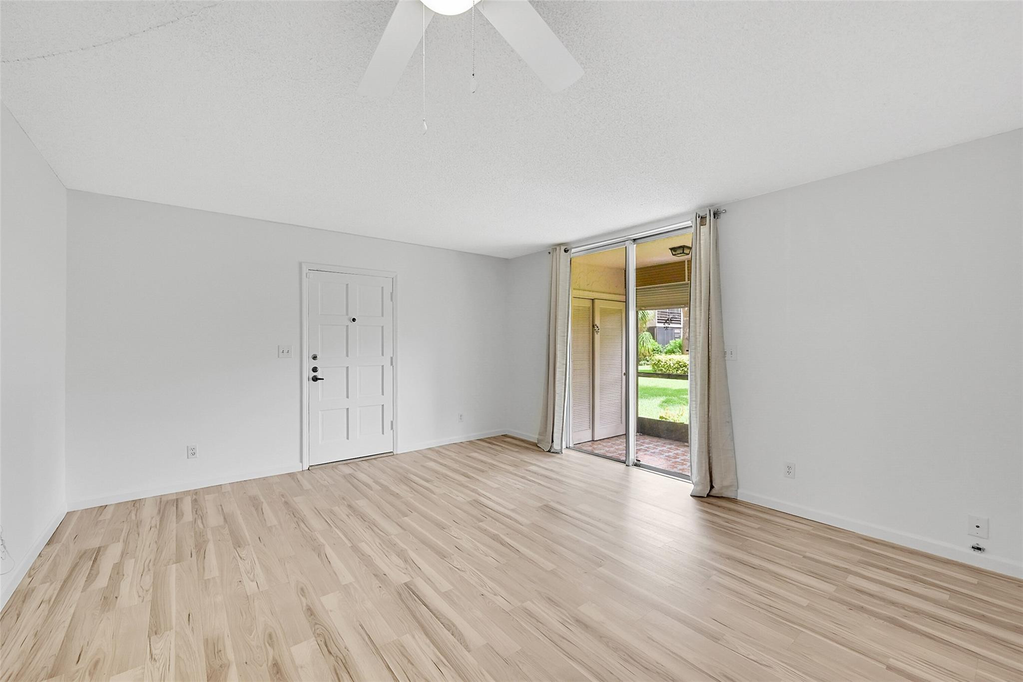 1024 Northwest 13th Street, Unit 149B Boca Raton, FL 33486 - Photo 7 of 42 a view of an empty room with wooden floor and a window