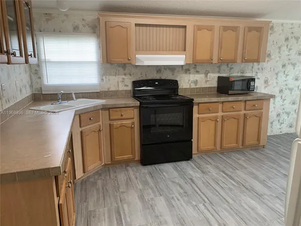 a kitchen with stainless steel appliances granite countertop a stove a sink and white cabinets