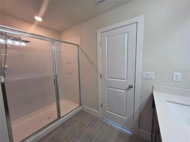 a bathroom with a shower and a glass door